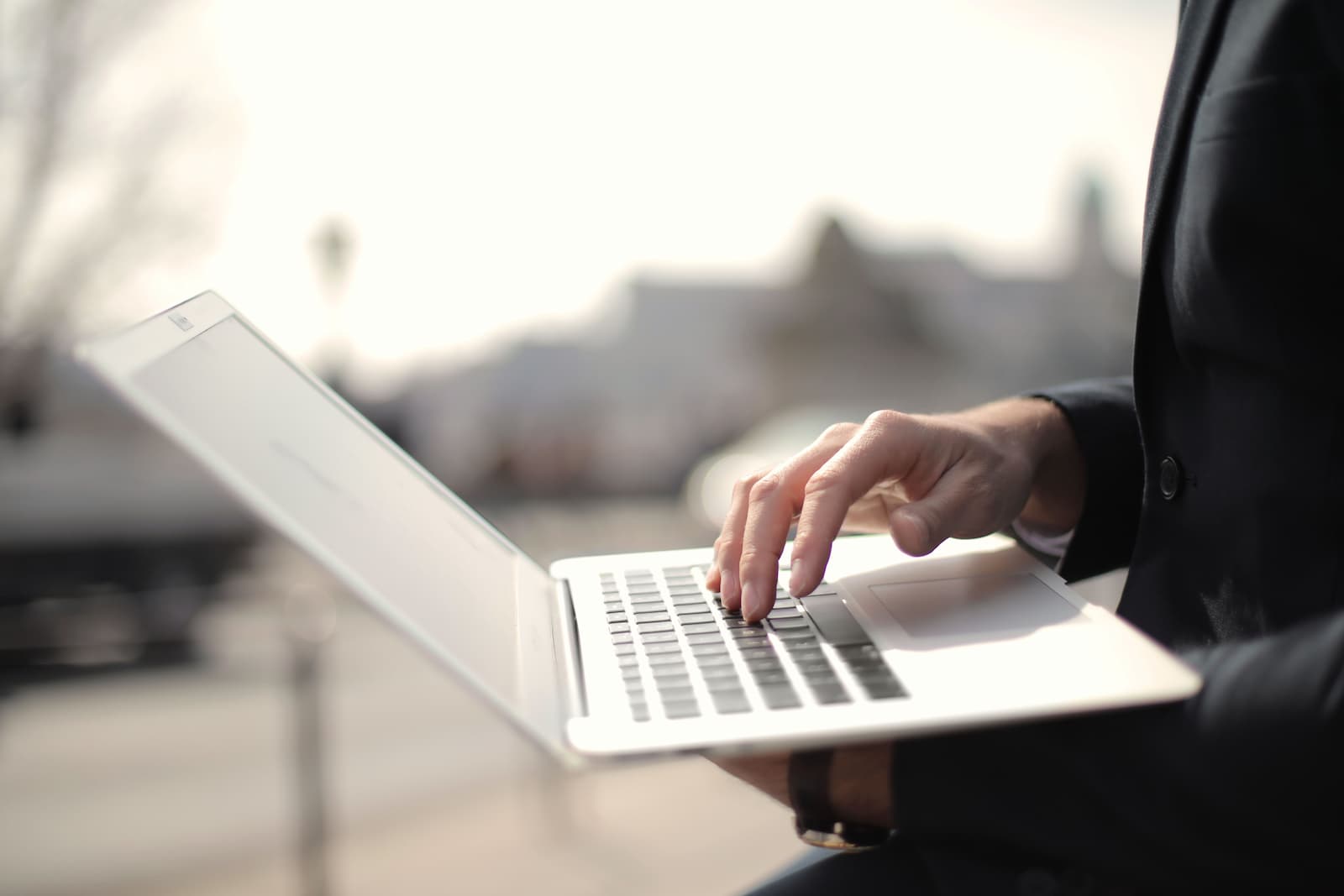 Unternehmer prüft am Laptop die Finanzierung einer Betriebsübernahme